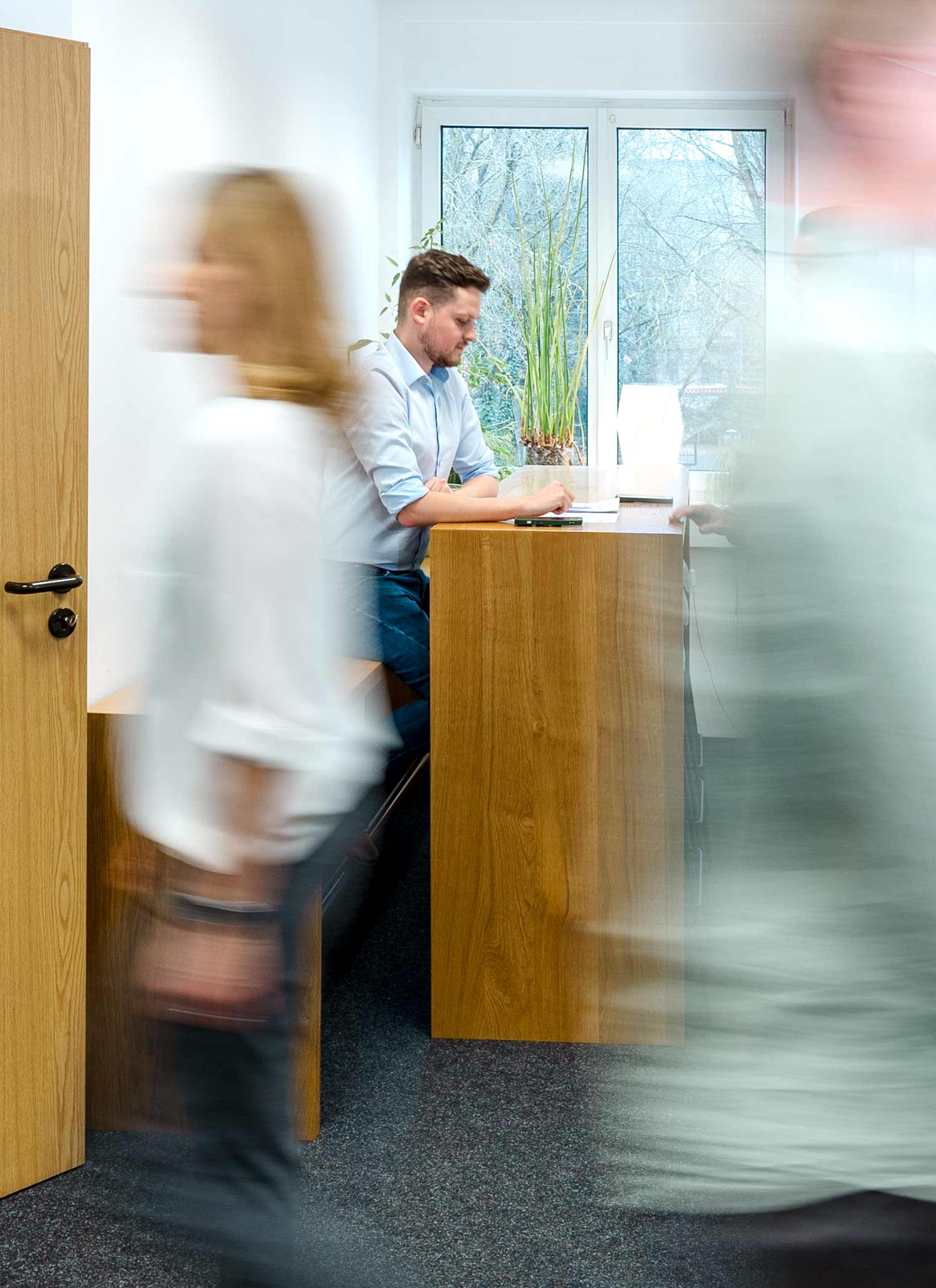 Verschiedene Mitarbeitende von re-sult laufen über den Gang im Regensburger Büro von re-sult.